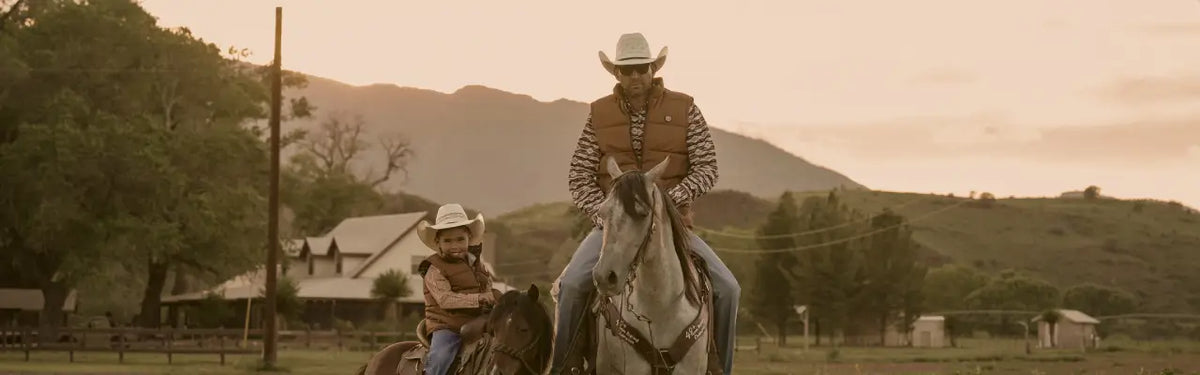 Cowboy and son wearing Tempco western outerwear on a ranch
